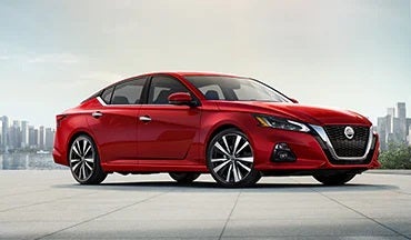 2023 Nissan Altima in red with city in background illustrating last year's 2022 model in Michael Jordan Nissan in Durham NC